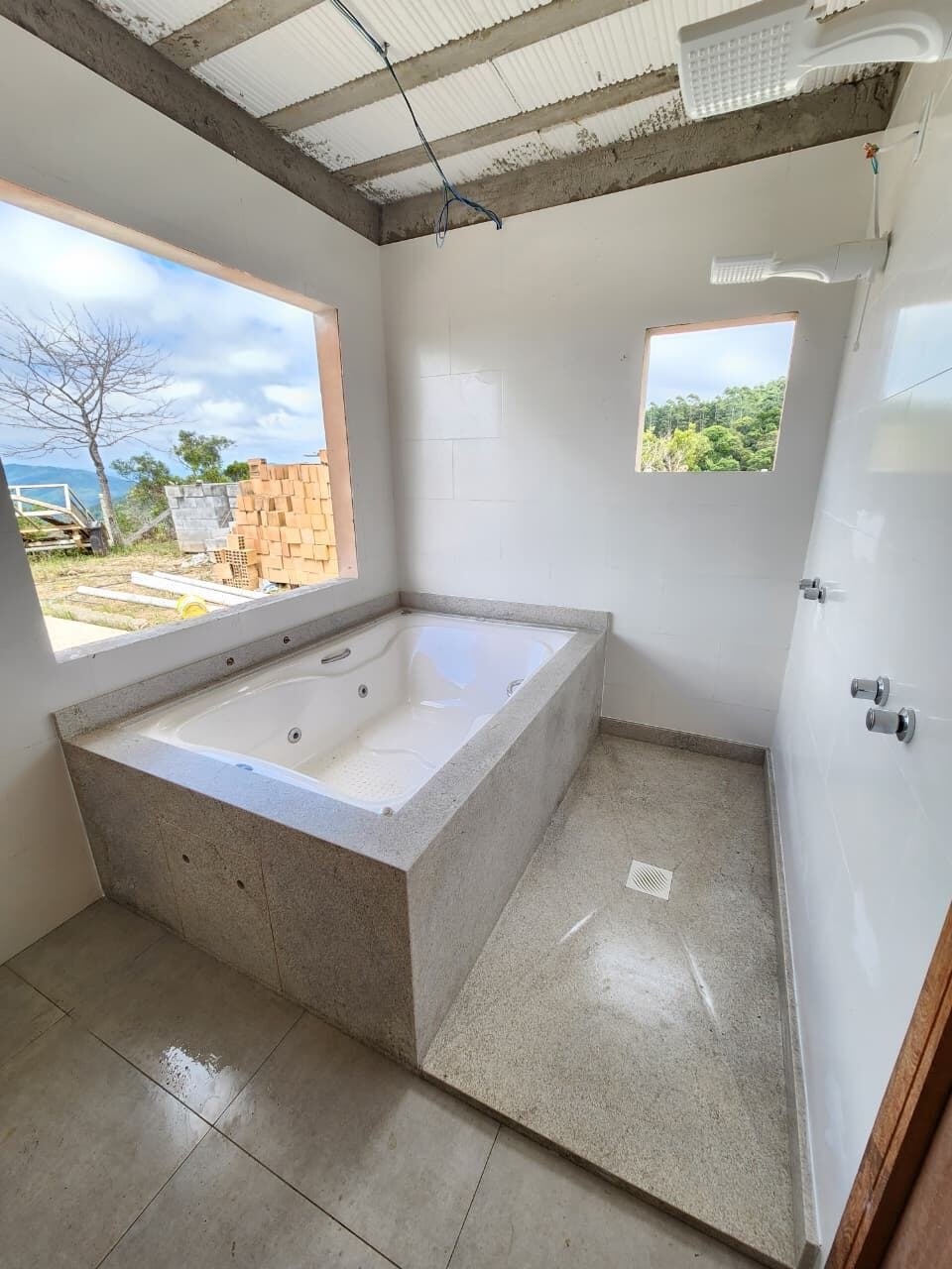 Banheira de hidromassagem com borda em granito, obra em acabamento