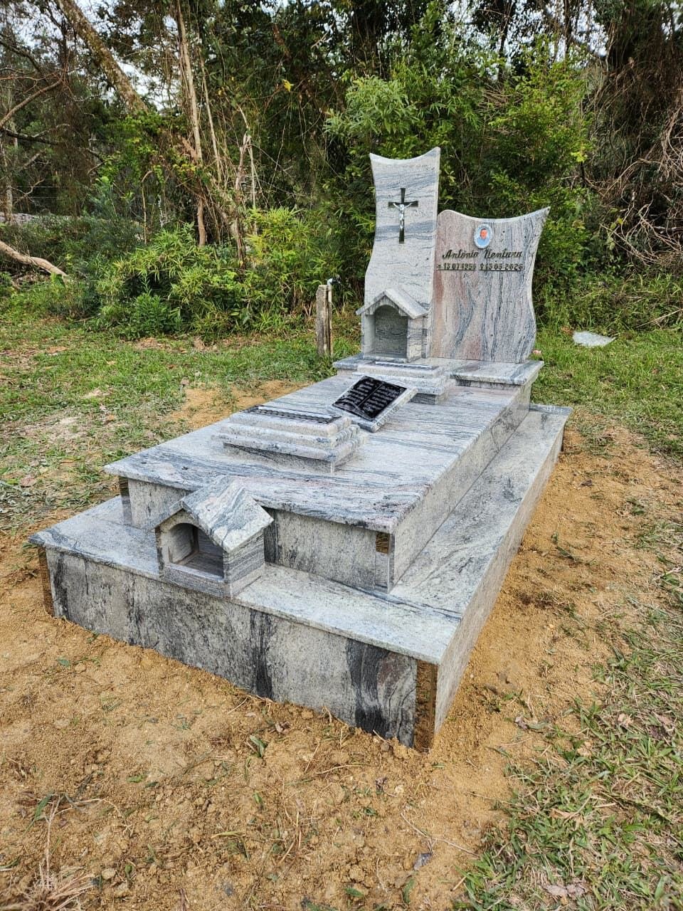 Túmulo em granito cinza com oratório e cruz esculpida