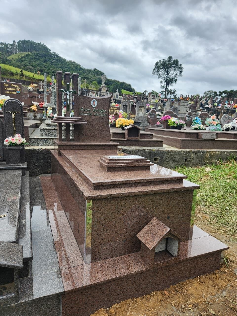 Túmulo em granito rosa com oratório e cruz em metal